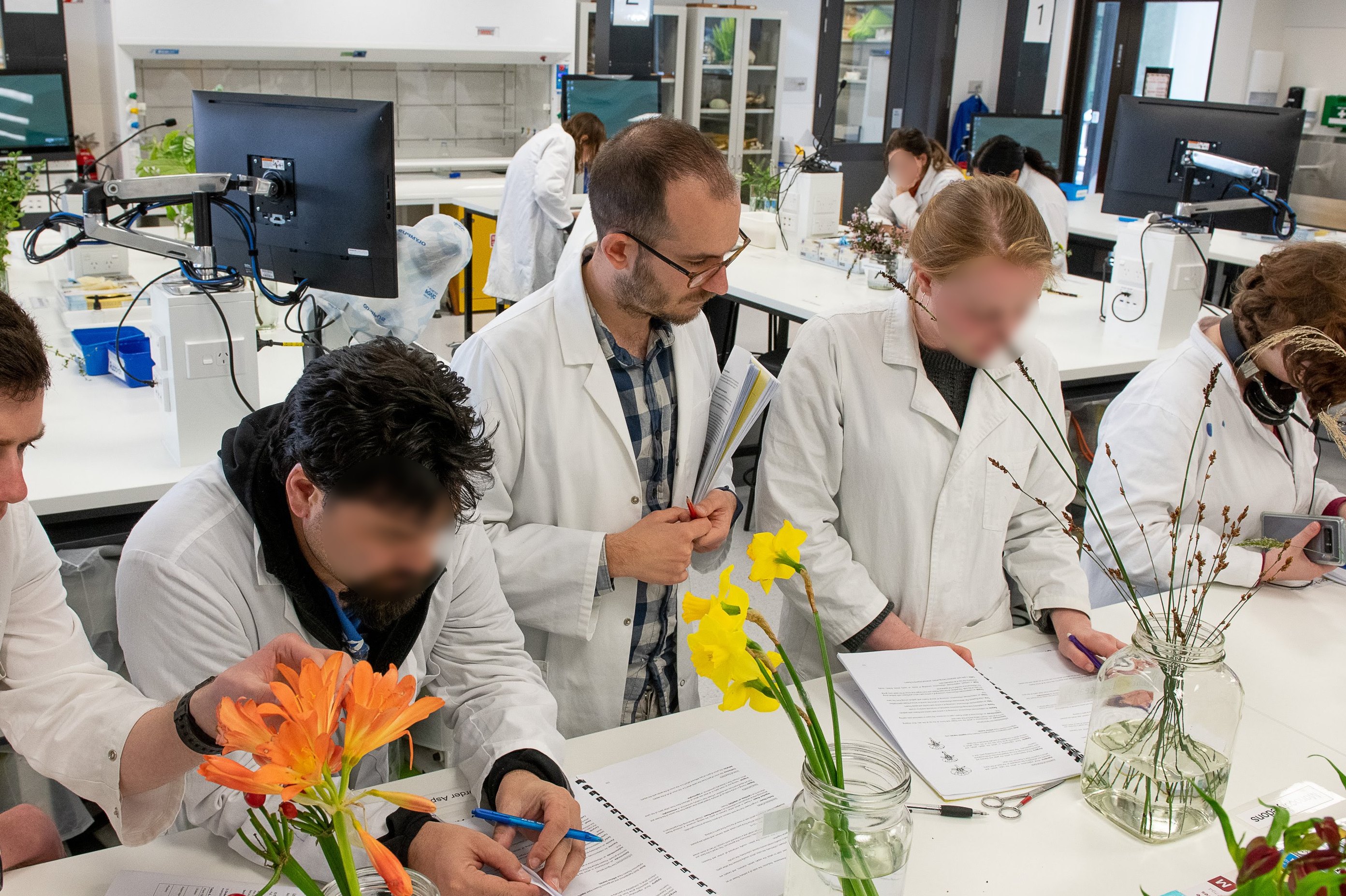 Fabio teaching in a laboratory with a couple of students, whose faces are blurred